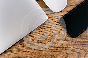 Laptop computer and smartphone, mouse on table. Office concept