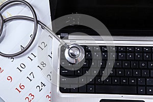 Laptop computer, stethoscope, and calendar