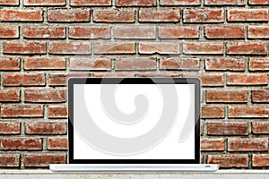 Laptop computer on table with brick wall background