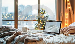 Laptop computer on white bed sheets in cozy modern hotel room with copy space blank screen and sunrise city view on the background