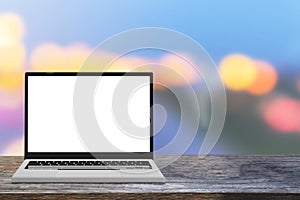 Laptop computer with white screen mockup front view table on wood table workplace and bokeh of The light background