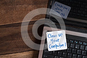 Laptop Computer on wooden table with note CLEAN UP YOUR COMPUTER