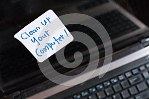 Laptop Computer on wooden table with note CLEAN UP YOUR COMPUTER