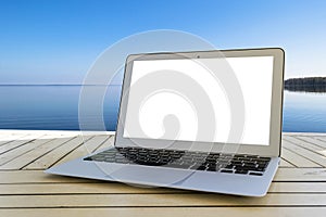 Laptop computer on wooden table. Top ocean view. Tropical island background. Open blank laptop computer empty space. Front view