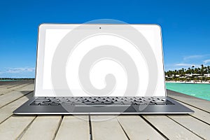 Laptop computer on wooden table. Top ocean view. Tropical island background. Open blank laptop computer empty space. Front view