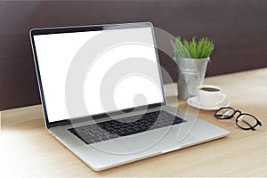 Laptop computer on work desk showing white screen side view