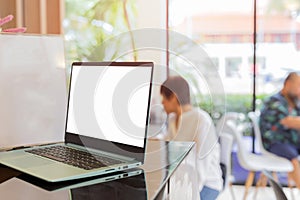 Laptop on counter bar with blurred customer in Coffee Shop.