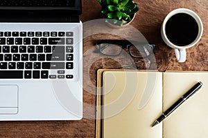 Laptop and cup of coffee on old wooden table