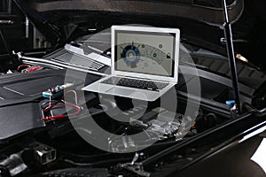 Laptop with diagram on auto engine. Car diagnostic photo