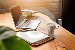 Laptop, diary, pen and cup on the desktop. Office tools.