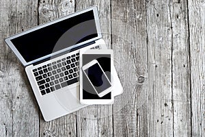 Laptop with digital tablet and mobile phone on wooden table