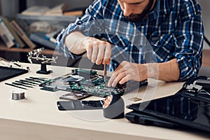 Laptop disassembling with screwdriver at repair