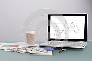 Laptop and documents on tabletop.