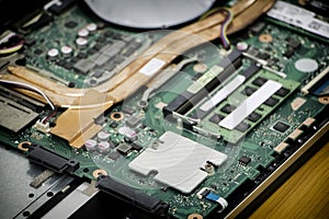 Laptop in Electronic repair shop.Laptop computer motherboard opened for upgrade and cleaning. technician repairing broken laptop