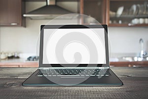 Laptop with empty blank screen on wooden tabletop with modern blur kitchen background