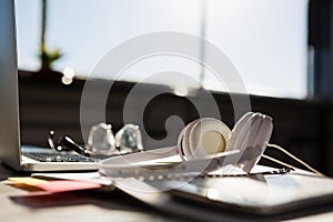 Laptop with eyeglasses by headphones on table