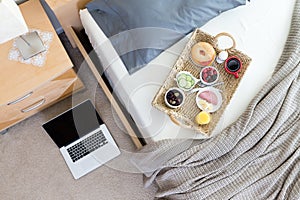 Laptop on Floor Beside Bed with Breakfast Tray