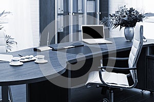 Laptop and flowers on table in a modern office