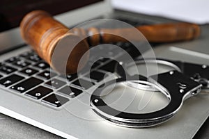 Laptop, gavel and handcuffs on table. Cyber crime