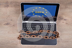 Laptop with GDPR letters in EU stars on wood background