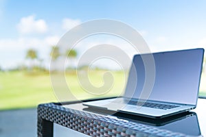 Laptop on golf course blur background with copy space, business or work from anywhere concept, depth of field effect