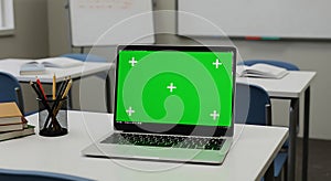 Laptop with Green Screen Mockup in Empty Classroom Setting