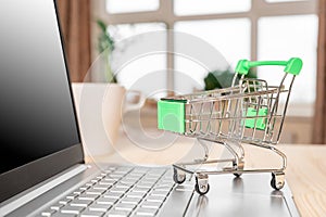 Laptop and grocery trolley. Online shopping concept. Shopping Cart on Laptop