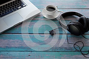 Laptop, Headphone, Music player, black coffee on blue wood table. With copy space. Business concept