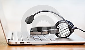 Laptop with headphones or headset on white desk