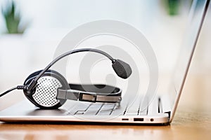 Laptop with headphones or headset on white desk