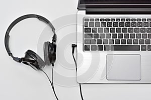 Laptop with headphones for listen music and audio books, online learnings, remote working.