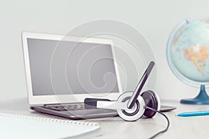 Laptop with headphones on white desk