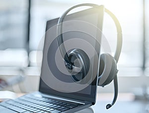 Laptop, headset and empty office in call center for help desk, customer service or telemarketing. Tech support, computer