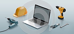 Laptop, helmet, drill and construction tools