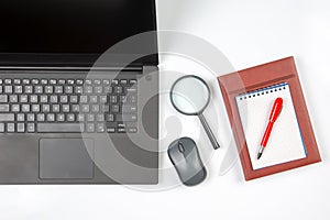 Laptop, magnifying glass, computer mouse, smartphone, pen, notepad on a white background. Items for business and buying goods