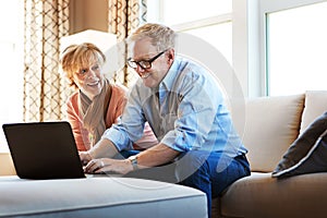 Laptop, mature or happy couple planning savings, property investment or online shopping together. Ecommerce website