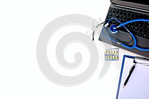 Laptop, medical device for listening stethoscope, Notepad, pills, capsules on white background, medical research, insurance and