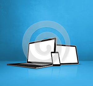 Laptop, mobile phone and digital tablet pc on blue office desk