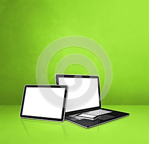 Laptop, mobile phone and digital tablet pc on green office desk