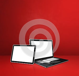 Laptop, mobile phone and digital tablet pc on red office desk