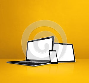 Laptop, mobile phone and digital tablet pc on yellow office desk