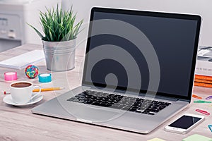 Macbook laptop mockup on office desk with smartphone and cup of coffee photo