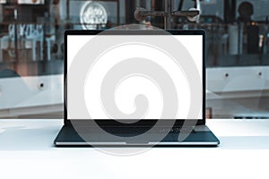 Laptop mockup with white screen in business office or shopping mall. Empty copy space, blank screen mockup. Soft focus