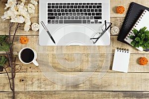 Laptop, notebook, diary and coffee on wood background.