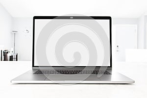 Laptop open with blank screen on a white table