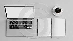 Laptop with an open screen is placed on the left next to an open