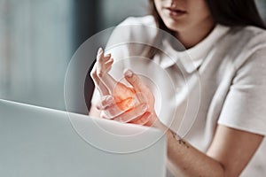 Laptop, pain in hand and woman in office with wrist injury from writing, typing and working on computer. Stress, medical