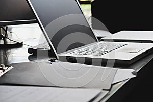 Laptop and papers on desk close up