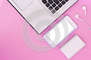Laptop, phone, headphones and power bank on a pink background. Flat Lay composition and place for text. Top view.