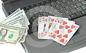Laptop, playing cards and dollars